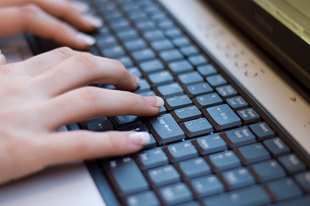 young womans manicured hands on keyboard